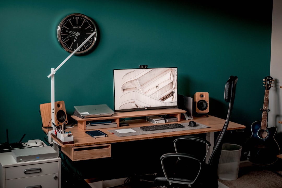 A desk featuring a computer, keyboard, and speakers, arranged for an efficient workspace.